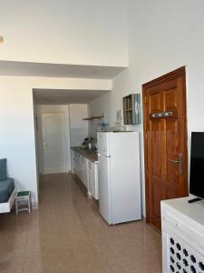 a kitchen with a white refrigerator in a room at La Vista Bonita in Corralejo