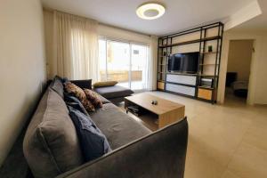 a living room with a couch and a coffee table at Feeling Home Garden Apartment in Herzliya