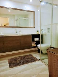 a bathroom with a sink and a toilet and a mirror at Feeling Home Garden Apartment in Herzliya