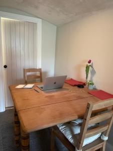 a wooden table with a laptop on top of it at Brook Cottage in Holmfirth