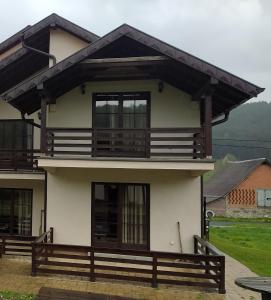 a white house with a balcony on top at Apartmani Draškovic - Goč in Biserske Kuće