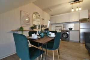 a dining room and kitchen with a table and chairs at Appartement BELLO , cœur de ville, boîte à clé, climatiseur mobile in Lons-le-Saunier
