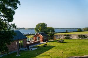 ein Gebäude auf einem Feld neben einem Wasserkörper in der Unterkunft Normanton Park House - Luxury Rutland Water Home in Oakham