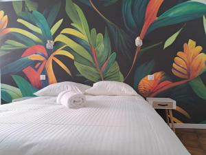 een bed met handdoeken in een kamer met een muurschildering bij Tulle - quartier historique in Tulle