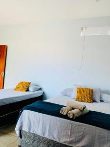 duas camas sentadas uma ao lado da outra num quarto em Portuá Chalés em São Miguel dos Milagres