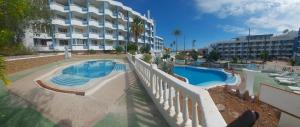 a large swimming pool next to a large building at Apartamento Golf del Sur in San Miguel de Abona