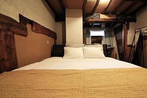 a bedroom with a large bed with white sheets and pillows at TOKYO HOUSE INN - Vacation STAY 52042v in Tokyo