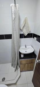 y baño con lavabo y ducha. en Increíble Apartamento Familiar, en Bogotá