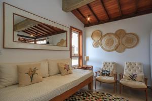 蒂拉登蒂斯的住宿－Sua Casa Tiradentes，客厅配有沙发和两把椅子