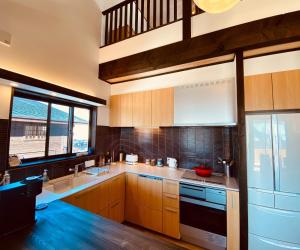 a kitchen with wooden cabinets and a large window at Snowman apartments - Vacation STAY 15949v in Iiyama