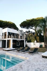 a house with chairs and a swimming pool at Villa GAULTHIER in Marbella