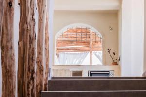 an arched window in a living room with stairs at Desart Hostel in Agadir