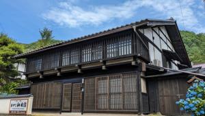 un edificio en blanco y negro con una puerta en Former inn "Oyado Wada-juku" - Vacation STAY 16383v, en Nagawa