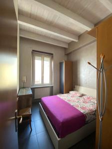een slaapkamer met een paars bed en een bureau bij Quattrozerotre in Turijn