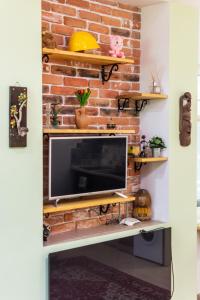 a living room with a brick wall and a television at Barcelona cute colorful apt w green backyard in Sofia