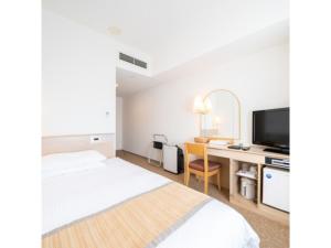 um quarto de hotel com uma cama e uma secretária com uma televisão em Hotel Terrace The Square Hitachi - Vacation STAY 21902v em Hitachi