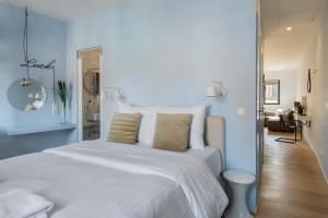 um quarto com uma cama branca e uma parede azul em R73 Apartments by Domani Hotels em Antuérpia