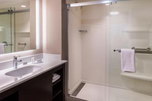 a bathroom with a sink and a glass shower at Residence Inn by Marriott Seattle University District in Seattle