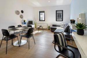 een woonkamer met een tafel en stoelen en een bank bij R73 Apartments by Domani Hotels in Antwerpen