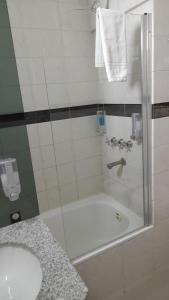 a bathroom with a shower with a tub and a sink at Temporarios NYC2 - Centro CBA in Cordoba
