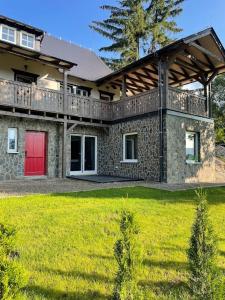 una casa grande con una puerta roja y un patio en Czerwone Drzwi en Stronie Śląskie
