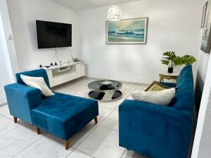 a living room with two blue chairs and a tv at Casa en San Fernando Pachacamac in Lima
