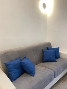 a couch with blue pillows on it in a room at DomoDé in Alghero