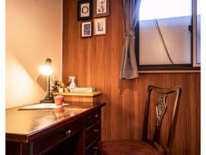 Hakugei Ryokan - Vacation STAY 30349v في طوكيو: غرفة مع مكتب مع كرسي ونافذة