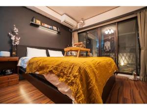 a bedroom with a bed with a yellow blanket on it at Hakugei Ryokan 2 - Vacation STAY 30359v in Tokyo