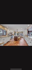 a large kitchen with white cabinets and a table at Resort type home in Old Brookvile !!! in Glen Head