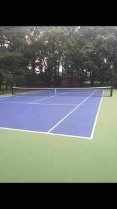 a tennis court with a tennis net on it at Resort type home in Old Brookvile !!! in Glen Head