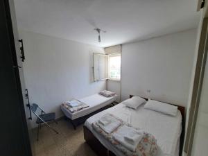 um pequeno quarto com uma cama e uma janela em Unforgettable cozy corner in Tzfat em Safed