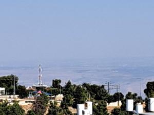 uma vista para uma cidade com árvores e o oceano em Unforgettable cozy corner in Tzfat em Safed