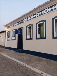 un edificio blanco con una puerta azul en una calle en Pousada A Pérola en Rio de Contas