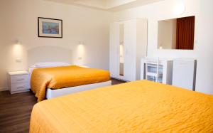 two beds in a hotel room with orange beds at Victoria Royal Garden in Como