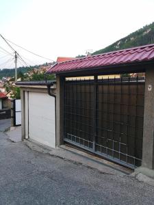 een garage met twee witte deuren en een rood dak bij Apartment Bistrik 1 in Sarajevo