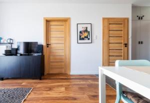 a living room with wooden doors and a table at Apartament doris doris in Poznań