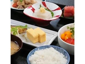 a table topped with plates of food with rice and fruit at Daikokuya Ryokan - Vacation STAY 53558v in Hakodate