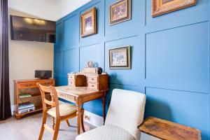 a blue room with a wooden desk and a chair at A Quaint and Delightful Abode in Normanhurst in Carshalton