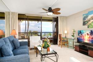 a living room with a blue couch and a tv at KBM Resorts KVR-F405 1 bdrm Includes Rental Car in Kaanapali