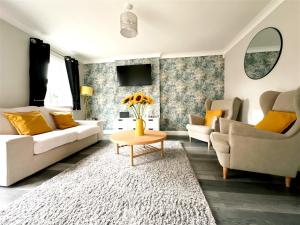 Cheerful two-bedroom townhouse near Leeds and York في ليدز: غرفة معيشة مع أريكة وطاولة