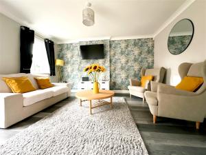 a living room with a couch and a table at Stylish Village Townhouse w/ Parking – Near Leeds & York in Leeds
