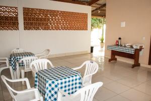 a dining room with two tables and white chairs at POUSADA REAL DAS FLORES in Porto Velho