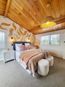 a bedroom with a large bed with a wooden ceiling at Fiji Vibe 4 Bedroom Oasis in Rototuna North in Hamilton