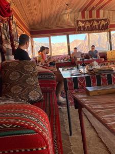a group of people sitting at a table on a train at Omar Ghazi Camp in Wadi Rum