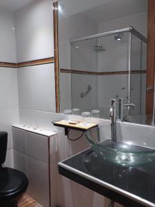 a bathroom with a glass sink and a tub at Spondylus in Huanchaco