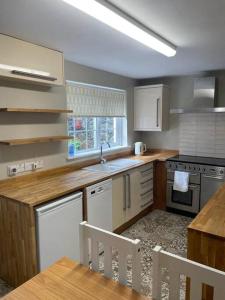 a kitchen with white appliances and a table and chairs at Millview Cottage in Castledawson