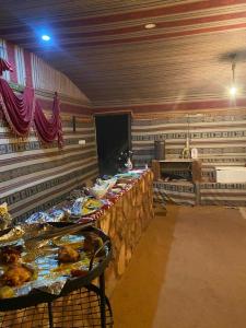 een kamer met meerdere tafels met eten erop bij Omar Ghazi Camp in Wadi Rum