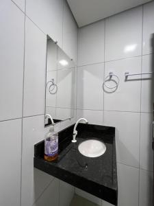 ein Bad mit einem Waschbecken und einem Spiegel in der Unterkunft Acomodação aconchegante próximo ao centro in Garanhuns
