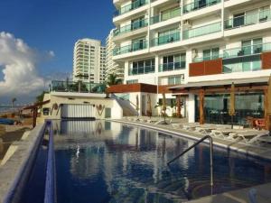 a large swimming pool in front of a building at Caribbean Ocean view at the hotel zone in Cancún